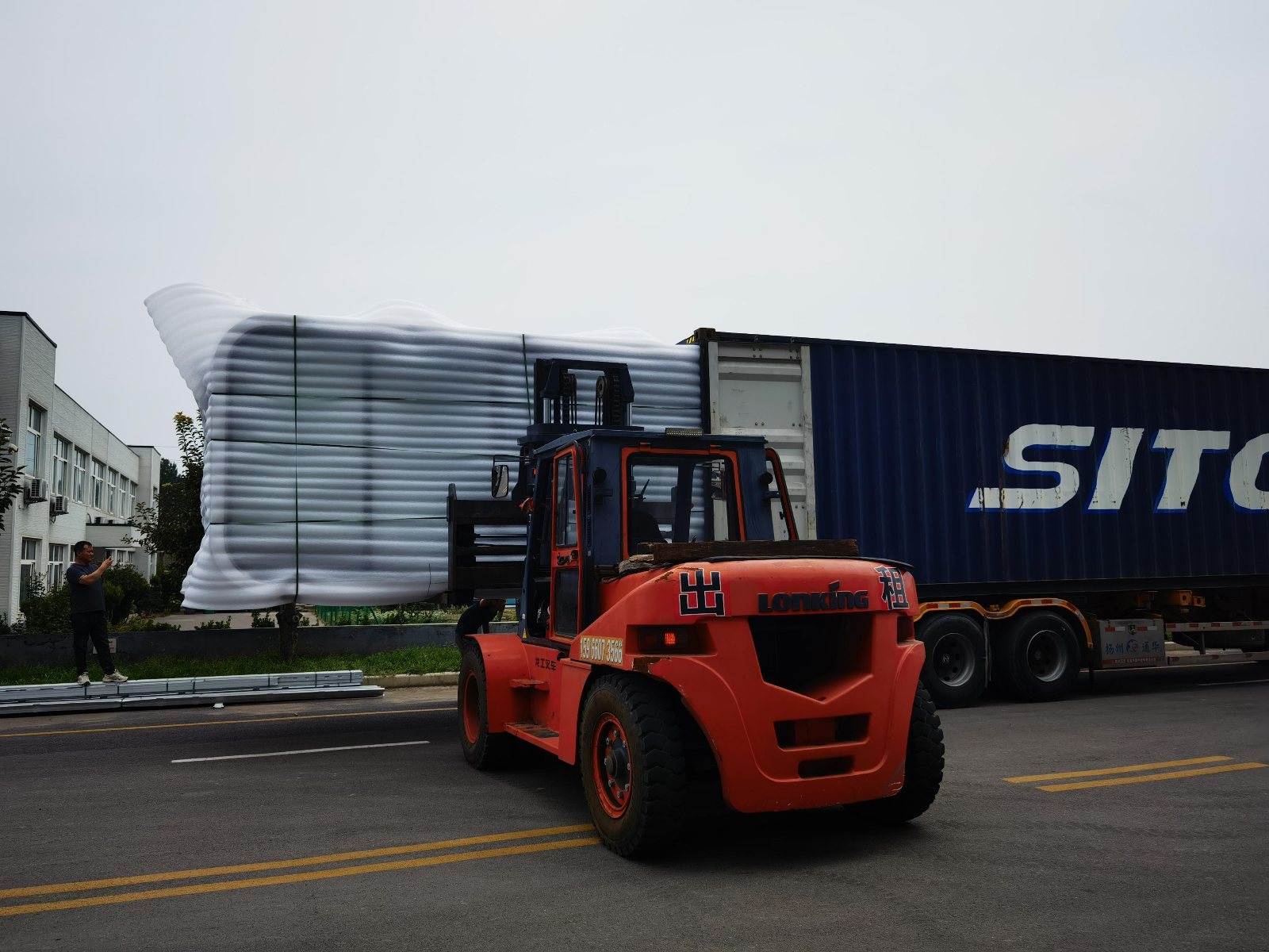 Forklift loading a Home Pod into a container